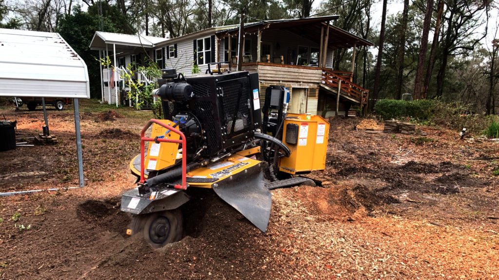 The bandit sg 75 grinding a stump in the front yard of a house in live oak florida